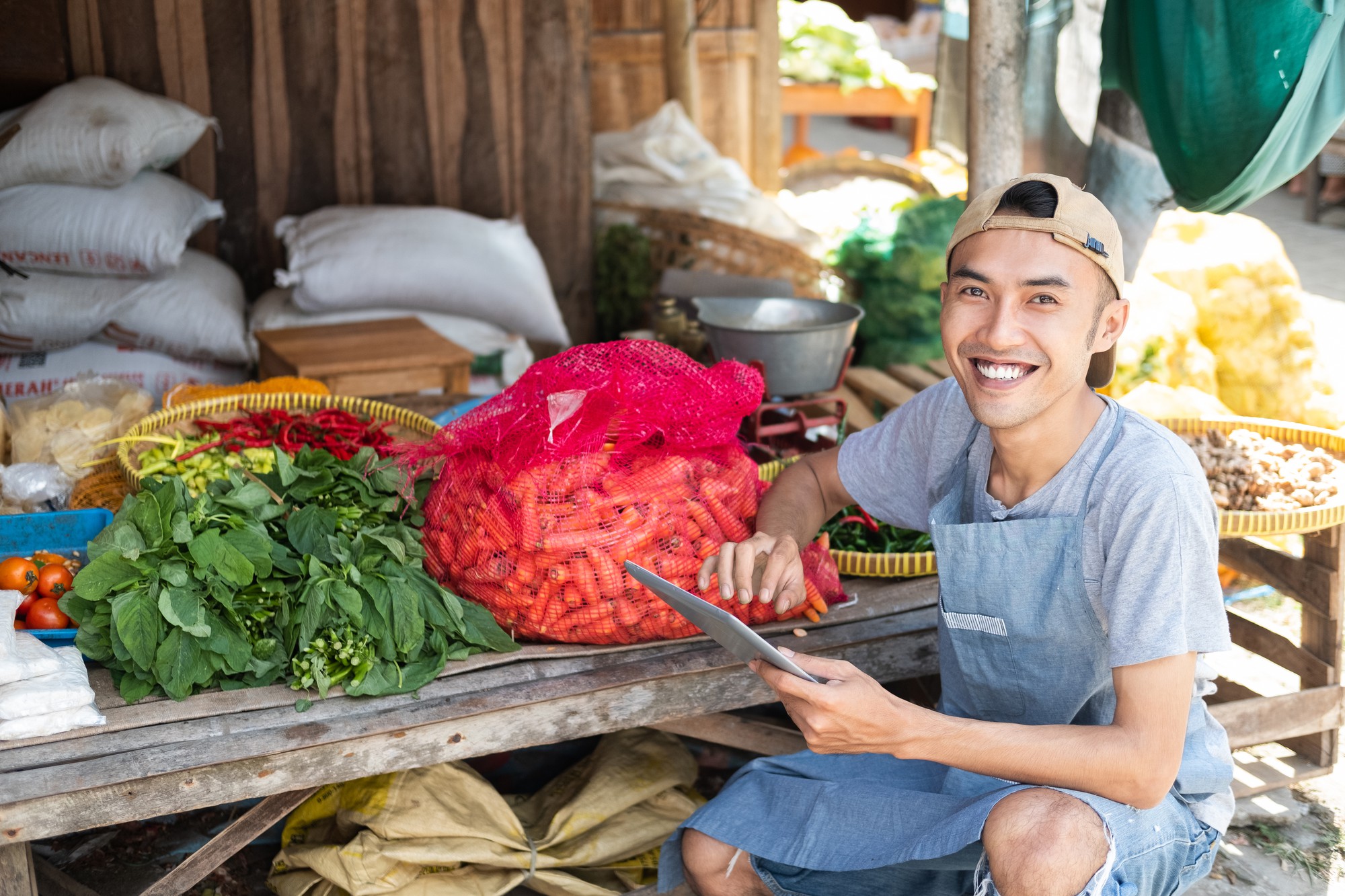 Small local market with vegetables and smiling vendor
